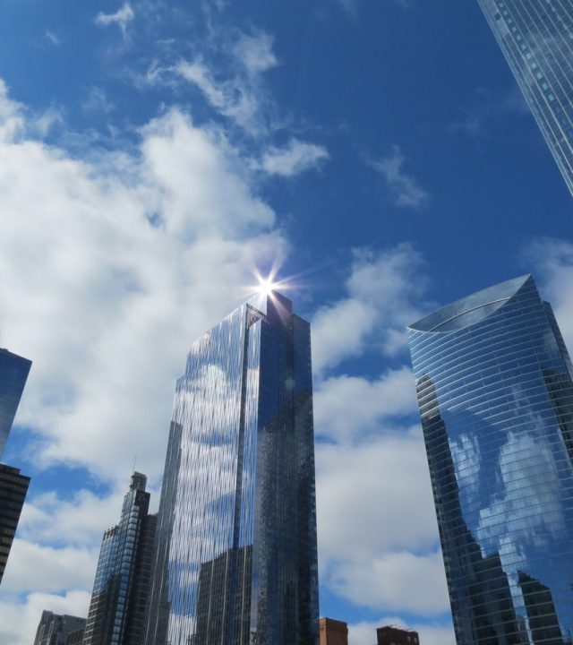 Modern architectural skyline with reflective skyscrapers under a bright blue sky in Chicago, Illinois.